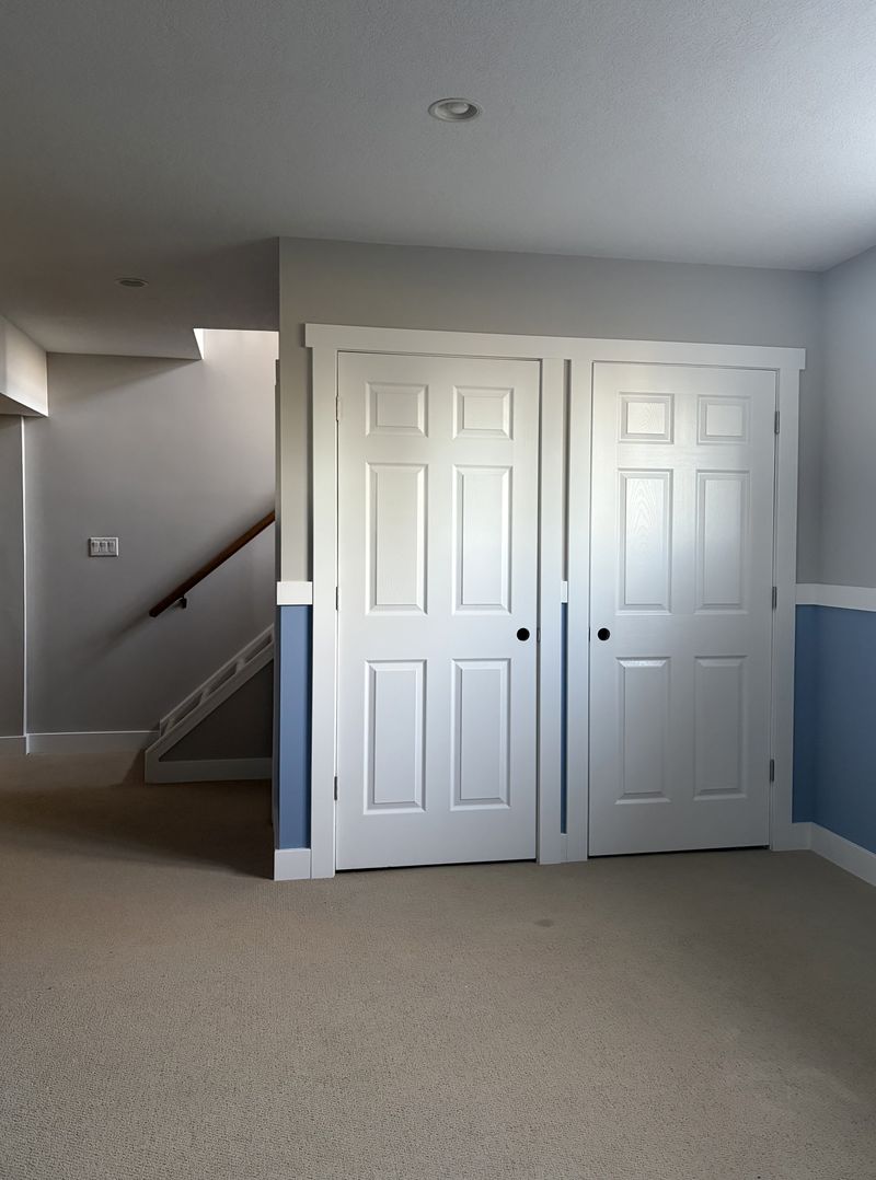 Basement living space with crisp blue and tan two-tone walls painted by Paint Pure